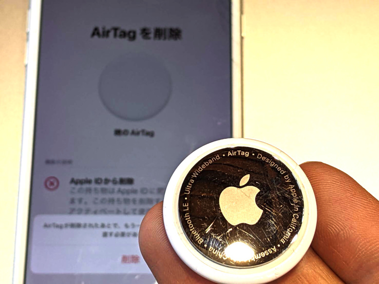 AirTagを削除を進めているiPhoneの画面とAirTag本体